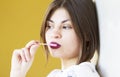 A beautiful and smiling girl enjoys a lollipop..