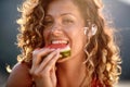 beautiful girl with a flower in her hair eats a watermelon