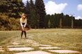 Beautiful girl in a hat in a vintage dress walking in a Summertime park