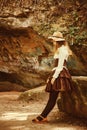 Beautiful girl in a hat in a vintage dress. Summertime park in mountains