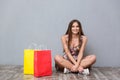 Beautiful smiling girl sitting on the floor with legs crossed Royalty Free Stock Photo