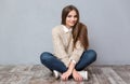 Beautiful smiling girl sitting on the floor with legs crossed Royalty Free Stock Photo