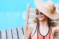 beautiful smiling girl in swimsuit and sunglasses resting on chaise lounge Royalty Free Stock Photo