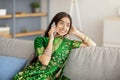 Beautiful smiling Indian woman in sari dress making phone call indoors