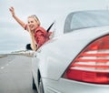 Beautiful smiling lady look out from car window on the highway