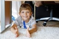 Beautiful Smiling Little Boy Portrait under school table. Happy kid looking at the camera. Adorable child with blond Royalty Free Stock Photo