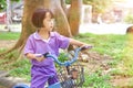 Beautiful smiling little girl riding bicycle in a park on sunny day outdoor Royalty Free Stock Photo