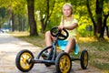 Beautiful smiling little girl riding toy car in Royalty Free Stock Photo