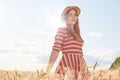 Beautiful smiling magnetic young woman having walk in sunny day, being at wheat field, touching stalks with hands, feeling rest, Royalty Free Stock Photo