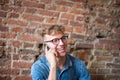 Happy man talking on mobile phone with friend, sitting against brick wall. Royalty Free Stock Photo