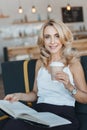 beautiful smiling mature woman reading book and drinking coffee Royalty Free Stock Photo