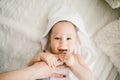 Beautiful smiling newborn baby boy covered with white bamboo towel with fun ears. lies on a white knit, wool plaid bright interior Royalty Free Stock Photo