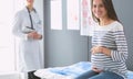 Beautiful smiling pregnant woman with the doctor at hospital