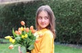 Beautiful smiling preteen girl at first date holding bouquet of spring yellow tulips Royalty Free Stock Photo