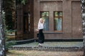 A beautiful smiling slender woman with long blond hair walks along the city street Royalty Free Stock Photo