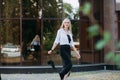 A beautiful smiling slender woman with long blond hair, walks along the city street Royalty Free Stock Photo