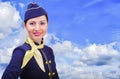 Beautiful smiling stewardess in uniform on a background sky