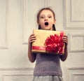 Beautiful smiling surprising cute girl holding the gold box with Royalty Free Stock Photo