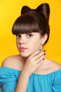 Beautiful smiling teen girl with bow hairstyle, makeup and colourful manicured polish nails. Funny girl in blue dress showing man Royalty Free Stock Photo