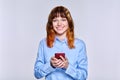 Beautiful smiling teenage female with smartphone in her hands looking at camera Royalty Free Stock Photo