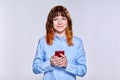 Beautiful smiling teenage female with smartphone in her hands looking at camera Royalty Free Stock Photo