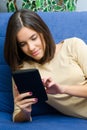 Beautiful smiling teenage girl using tablet at home Royalty Free Stock Photo