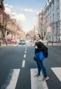 Beautiful smiling tourist woman with backpack standing on the crosswalk in the Belgrade city, Serbia Royalty Free Stock Photo