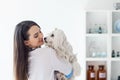 Beautiful smiling veterinarian doctor holding cute white dog Royalty Free Stock Photo