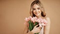 Beautiful smiling woman on beige background with flowers
