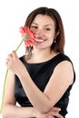 Beautiful smiling woman in black dress holds gerbera flower in hand Royalty Free Stock Photo