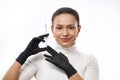 Beautiful smiling woman in black gloves holding a syringe near her face. Concept of injection cosmetology and anti-aging therapy Royalty Free Stock Photo