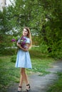 Beautiful woman in a blue summer dress with lilac flowers in a blooming garden. Spring Blossom Royalty Free Stock Photo