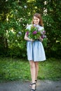 Beautiful woman in a blue summer dress with lilac flowers in a blooming garden. Spring Blossom Royalty Free Stock Photo