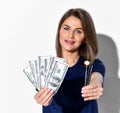 Beautiful smiling woman dentist or doctor orthodontist standing and holding dollars and dental tools in hands