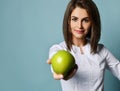 Beautiful smiling woman dentist or doctor orthodontist in traditional medical uniform offering green fresh apple to camera Royalty Free Stock Photo