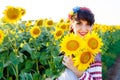 Beautiful smiling woman in embrodery holding three sunflowers Royalty Free Stock Photo