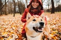 Beautiful smiling woman with her dog Akita Inu breed while walking in the autumn park. Happiness and fun with dog friendship Royalty Free Stock Photo