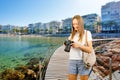 Beautiful smiling woman holding modern equipment for photography hobby on beach.