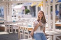 Beautiful woman holding paper coffee cup and enjoying the walk in the city