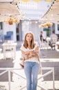 Beautiful woman holding paper coffee cup and enjoying the walk in the city