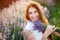 Beautiful smiling woman in lavender field. Beauty portrait of girl with lavender bouquet flowers. Close up face Royalty Free Stock Photo