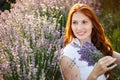 Beautiful smiling woman in lavender field. Beauty portrait of girl with lavender bouquet flowers. Close up face Royalty Free Stock Photo