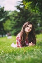 Beautiful smiling woman lying on a grass outdoor. Royalty Free Stock Photo