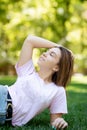 Beautiful smiling woman lying on a grass outdoor Royalty Free Stock Photo