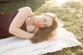 Beautiful smiling woman lying on a grass outdoor in sunny spring day. She is absolutely happy. Royalty Free Stock Photo