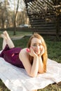 Beautiful smiling woman lying on a grass outdoor in sunny spring day. She is absolutely happy. Royalty Free Stock Photo