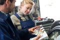 Beautiful smiling woman mechanic in blue with mentor