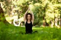 Beautiful smiling woman in morning park doing yoga and outdoor gymnastics. Green grass and rays of sun Royalty Free Stock Photo