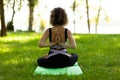 Beautiful smiling woman in morning park doing yoga and outdoor gymnastics. Green grass and rays of sun Royalty Free Stock Photo