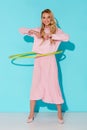 beautiful smiling woman in pink clothing exercising with hula hoop